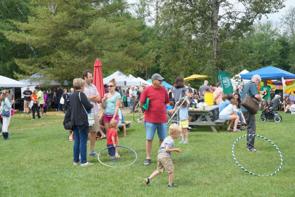 Kids play and people gather at a farmers market