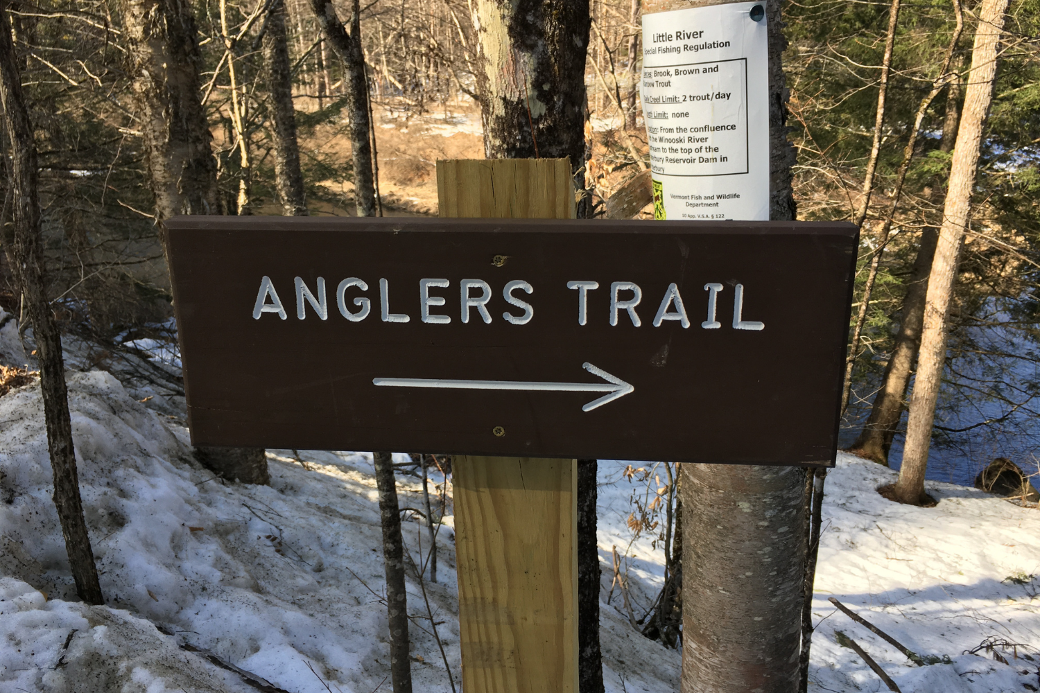 A sign at a trailhead during winter